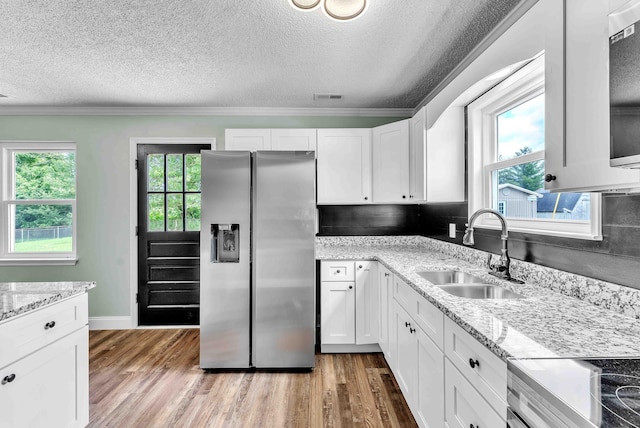 3010 Georgetown Dr NW, Cleveland, TN 37312 - kitchen featuring stainless steel fridge, a textured ceiling, light wood-style floors, crown molding, and white cabinetry