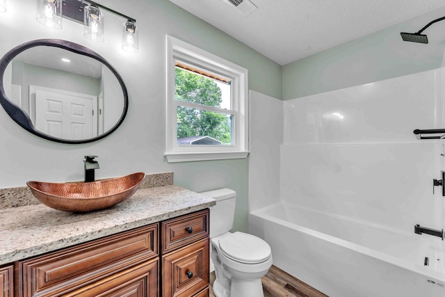 3010 Georgetown Dr NW, Cleveland, TN 37312 - bathroom featuring vanity, shower / tub combination, wood finished floors, and a textured ceiling