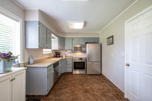1318 Joiner Rd, Chattanooga, TN 37421 - kitchen featuring appliances with stainless steel finishes, gray cabinetry, light countertops, crown molding, and backsplash