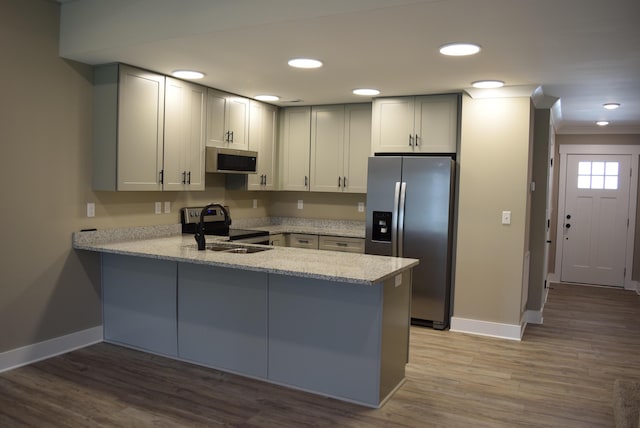 81 Morning Mist Dr, Rossville, GA 30741 - kitchen featuring appliances with stainless steel finishes, a peninsula, light wood-type flooring, light stone counters, and recessed lighting