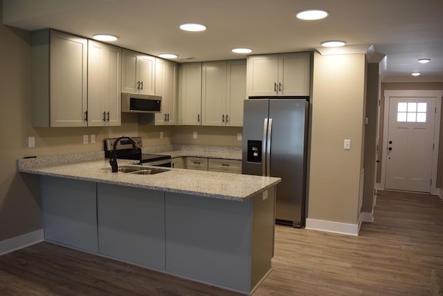81 Morning Mist Dr, Rossville, GA 30741 - kitchen featuring appliances with stainless steel finishes, a peninsula, light wood-style floors, light stone counters, and recessed lighting