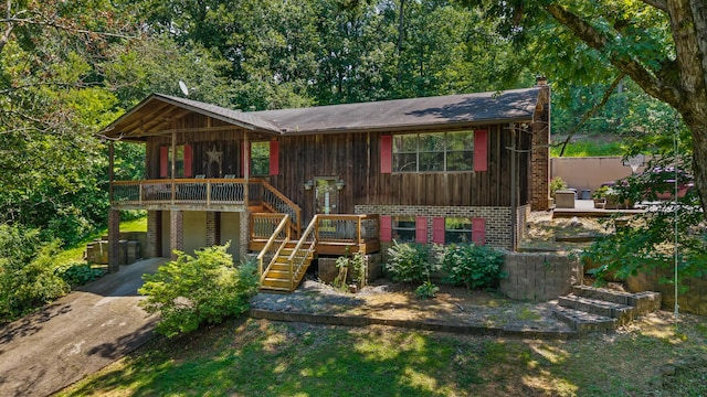 144 Bible Dr, Benton, TN 37307 - view of front of home with stairway, brick siding, concrete driveway, a deck, and a chimney
