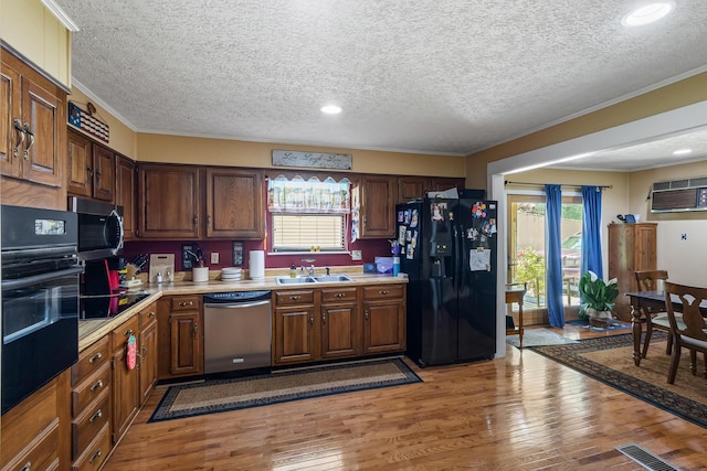 144 Bible Dr, Benton, TN 37307 - kitchen with black appliances, plenty of natural light, crown molding, light wood-style floors, and a textured ceiling