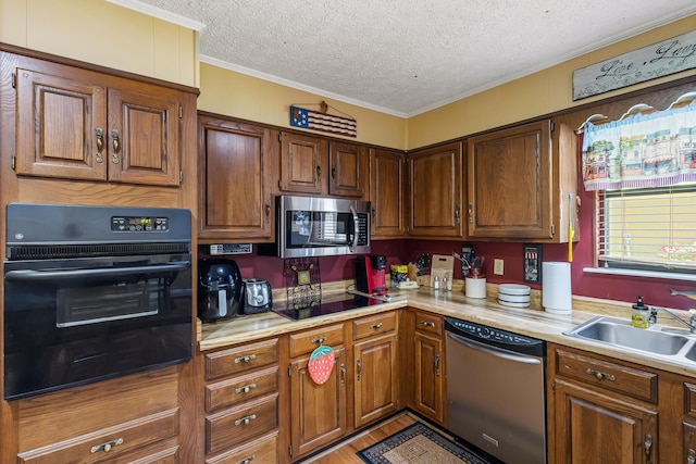 144 Bible Dr, Benton, TN 37307 - kitchen featuring black appliances, crown molding, light countertops, a textured ceiling, and brown cabinetry
