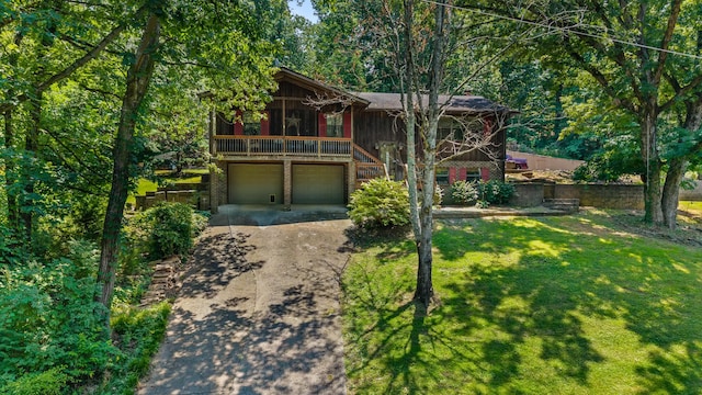 144 Bible Dr, Benton, TN 37307 - chalet / cabin with concrete driveway, a front lawn, an attached garage, and stairway