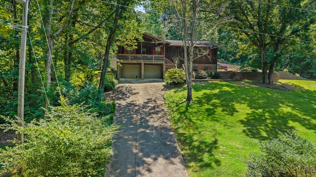 144 Bible Dr, Benton, TN 37307 - view of front of home with driveway, board and batten siding, a garage, a front yard, and a view of trees