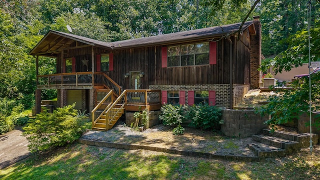 144 Bible Dr, Benton, TN 37307 - view of front facade featuring brick siding, stairs, a chimney, board and batten siding, and a wooden deck