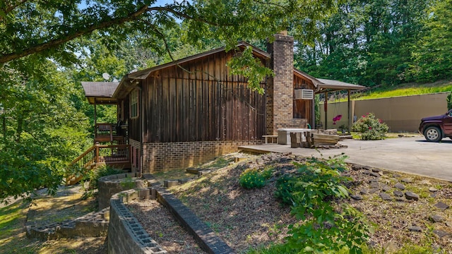 144 Bible Dr, Benton, TN 37307 - view of side of property featuring a chimney, board and batten siding, brick siding, stairway, and a patio