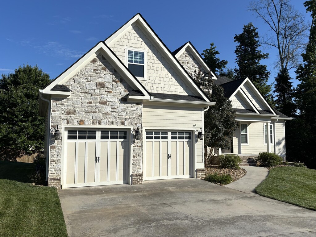 4138 Lone Elm Ln, Apison, TN 37302 - view of front of house featuring concrete driveway, stone siding, a front lawn, and an attached garage