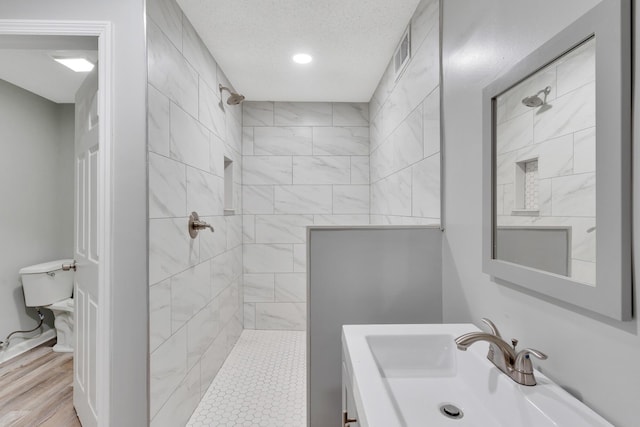 4212 Rogers Rd, Chattanooga, TN 37411 - bathroom featuring a tile shower, vanity, recessed lighting, and wood finished floors