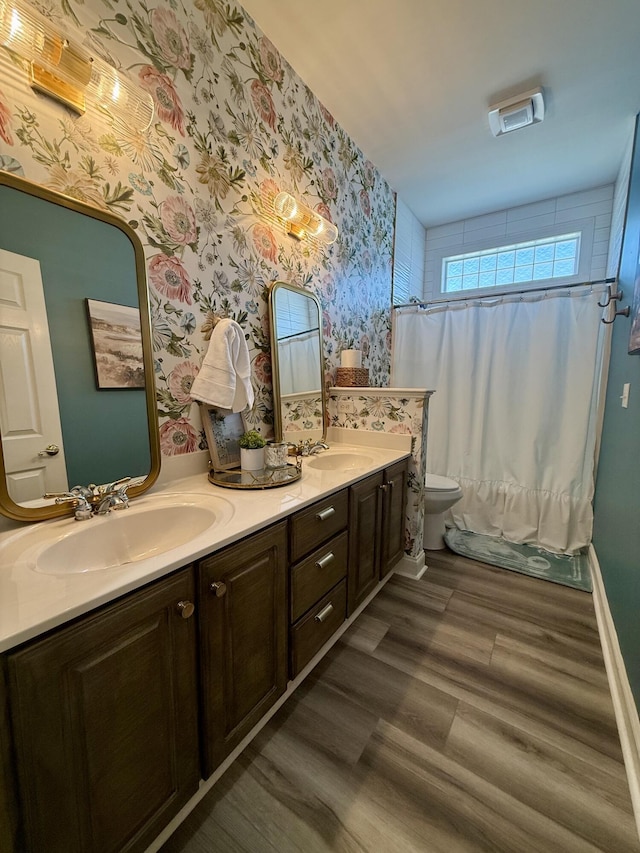 120 Oakhurst Ter NE, Calhoun, GA 30701 - bathroom featuring double vanity, wallpapered walls, wood finished floors, and shower / bath combo