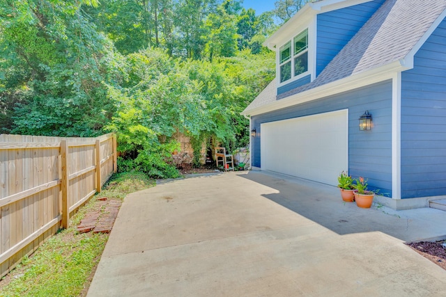 1132 Dartmouth St, Chattanooga, TN 37405 - view of side of property featuring a garage, a shingled roof, and driveway