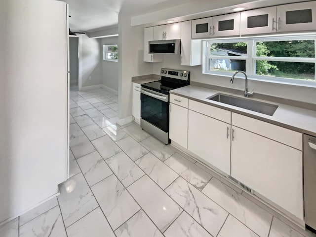 1116 Magnolia St, Lafayette, GA 30728 - kitchen featuring appliances with stainless steel finishes, light marble finish floors, and white cabinetry