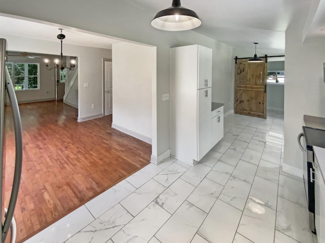 1116 Magnolia St, Lafayette, GA 30728 - kitchen featuring a barn door, light marble finish floors, and white cabinetry