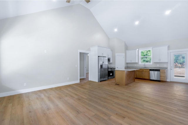 307 Cavender St, Lafayette, GA 30728 - kitchen featuring stainless steel appliances, open floor plan, high vaulted ceiling, a kitchen island, and white cabinetry