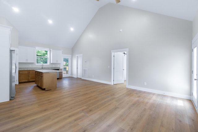 307 Cavender St, Lafayette, GA 30728 - kitchen with open floor plan, high vaulted ceiling, freestanding refrigerator, a center island, and light countertops