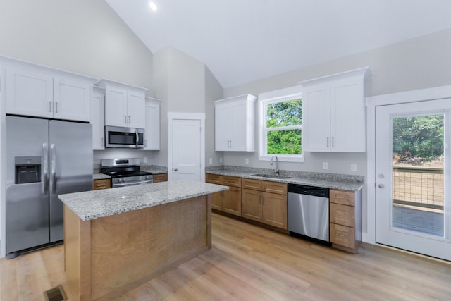 307 Cavender St, Lafayette, GA 30728 - kitchen featuring appliances with stainless steel finishes, high vaulted ceiling, a kitchen island, white cabinets, and light wood-type flooring