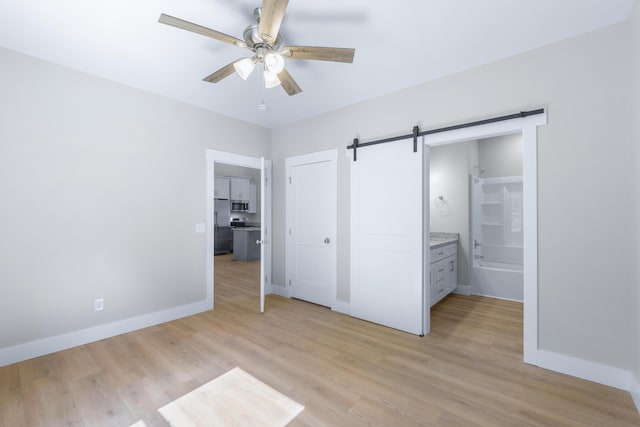 307 Cavender St, Lafayette, GA 30728 - unfurnished bedroom with a barn door, light wood-style floors, stainless steel fridge, and ensuite bathroom