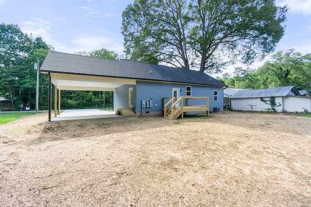 307 Cavender St, Lafayette, GA 30728 - rear view of house featuring an attached carport, dirt driveway, and roof with shingles