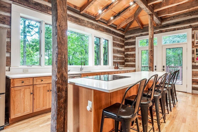 1908 Clear Brooks Dr, Signal Mountain, TN 37377 - kitchen featuring black electric cooktop, light wood-style floors, light countertops, a kitchen bar, and a kitchen island