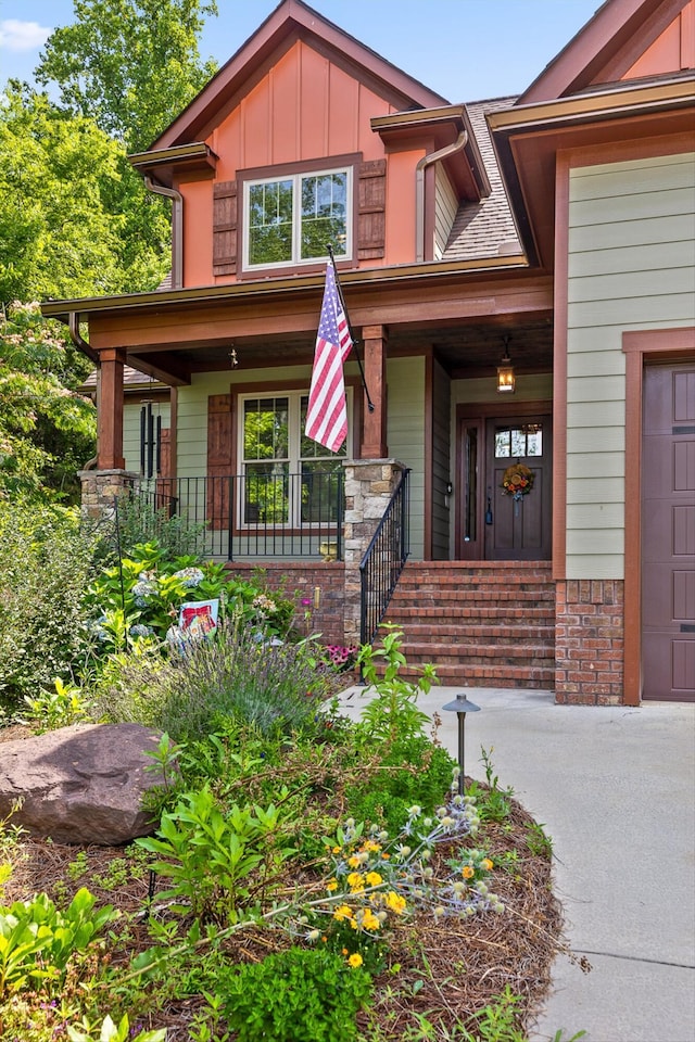 9795 Trestle Cir, Ooltewah, TN 37363 - view of front facade featuring covered porch, board and batten siding, and a garage