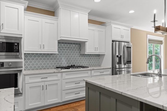 9795 Trestle Cir, Ooltewah, TN 37363 - kitchen with appliances with stainless steel finishes, white cabinets, ornamental molding, decorative backsplash, and light stone counters