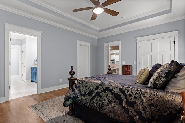 9795 Trestle Cir, Ooltewah, TN 37363 - bedroom with wood finished floors, crown molding, a tray ceiling, a closet, and ensuite bath