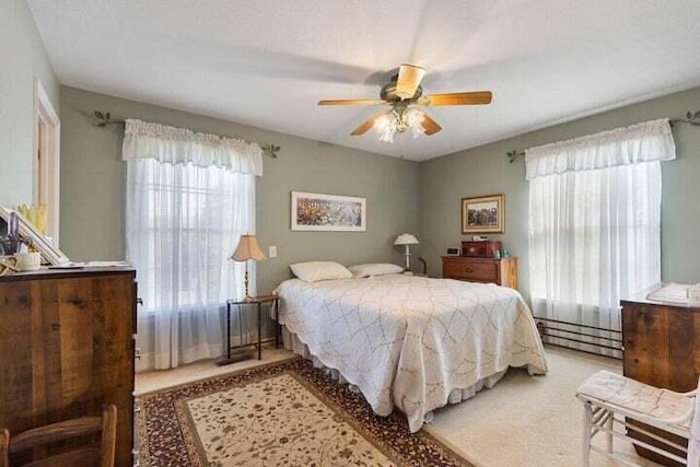 346 Thomas Rd, Benton, TN 37307 - bedroom with a baseboard heating unit, light colored carpet, and ceiling fan