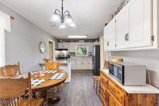 346 Thomas Rd, Benton, TN 37307 - kitchen featuring appliances with stainless steel finishes, light countertops, a chandelier, dark wood-type flooring, and white cabinetry