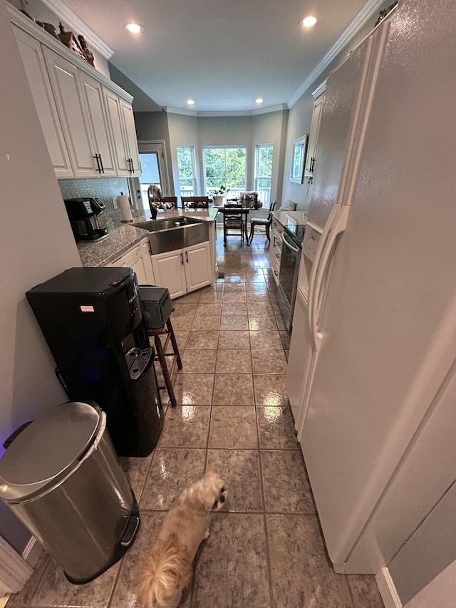 7901 Hamilton Mill Dr, Chattanooga, TN 37421 - kitchen featuring freestanding refrigerator, ornamental molding, a peninsula, decorative backsplash, and white cabinets