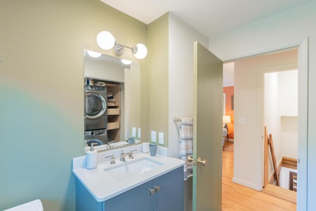 4205 Seneca Ave, Chattanooga, TN 37409 - bathroom featuring stacked washer and clothes dryer, vanity, and wood finished floors