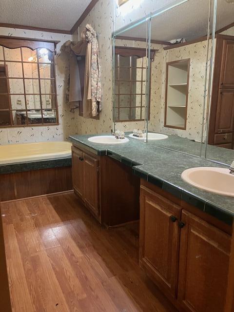 287 E Teems Rd, Ringgold, GA 30736 - full bathroom with wallpapered walls, wood finished floors, double vanity, ornamental molding, and a bath