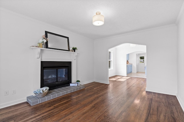 5014 Carolyn Ln, Chattanooga, TN 37411 - unfurnished living room featuring arched walkways, wood finished floors, a tile fireplace, and crown molding