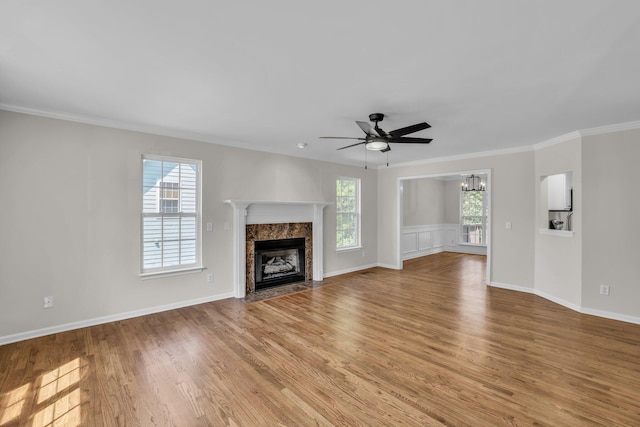 5586 Crooked Creek Dr, Ooltewah, TN 37363 - unfurnished living room with a premium fireplace, a ceiling fan, light wood finished floors, ornamental molding, and a chandelier