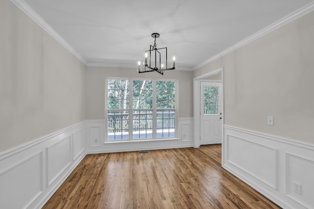 5586 Crooked Creek Dr, Ooltewah, TN 37363 - unfurnished dining area featuring a chandelier, wainscoting, a decorative wall, wood finished floors, and crown molding
