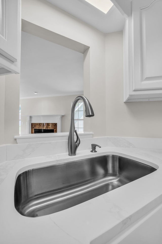 5586 Crooked Creek Dr, Ooltewah, TN 37363 - kitchen view of white cabinetry, a premium fireplace, and light stone counters