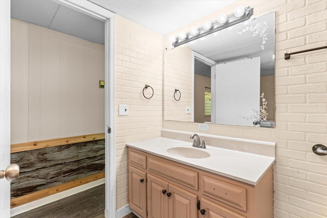 4621 Bramblett Dr SE, Dalton, GA 30721 - bathroom featuring vanity, wood finished floors, and brick wall