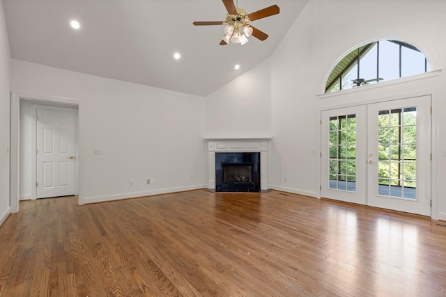 9539 Shadow Crossing Ln, Chattanooga, TN 37421 - unfurnished living room featuring high vaulted ceiling, a ceiling fan, a fireplace, wood finished floors, and french doors