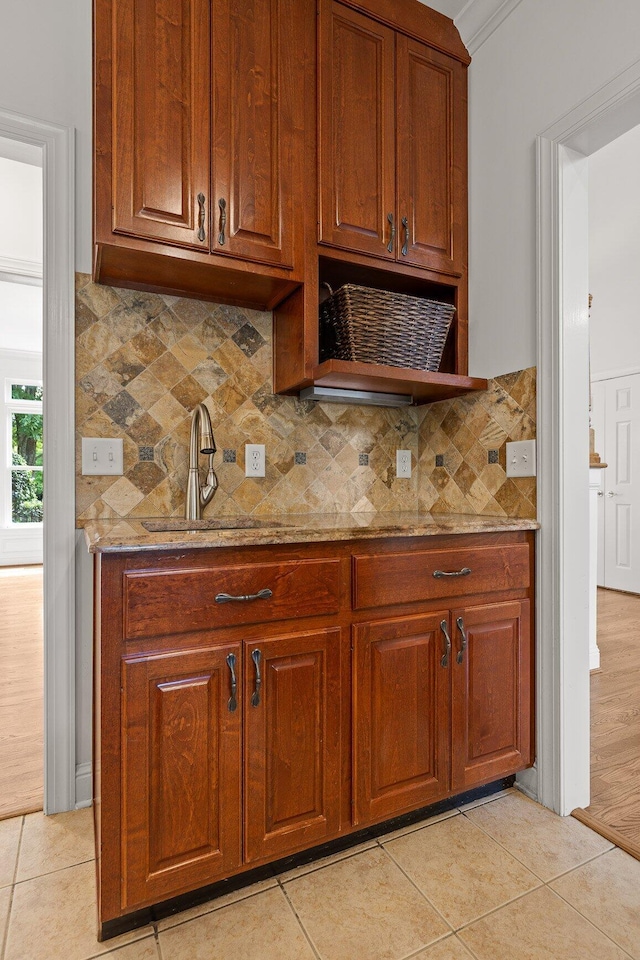 9539 Shadow Crossing Ln, Chattanooga, TN 37421 - kitchen featuring light stone counters, decorative backsplash, light tile patterned flooring, and brown cabinets