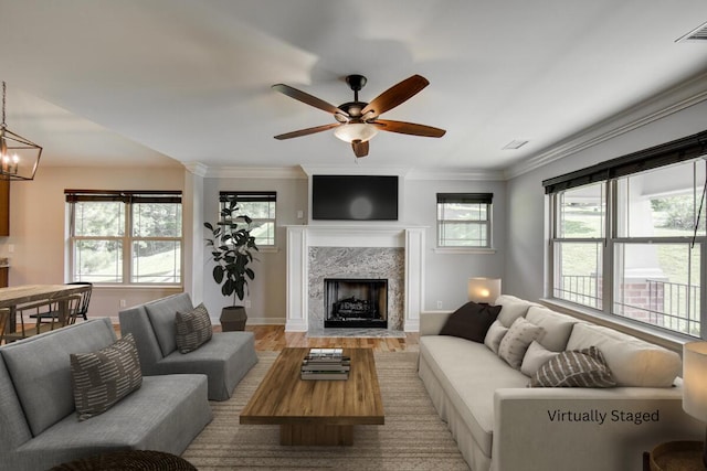 6253 River Stream Dr, Harrison, TN 37341 - living room featuring wood finished floors, ceiling fan, a premium fireplace, crown molding, and a chandelier