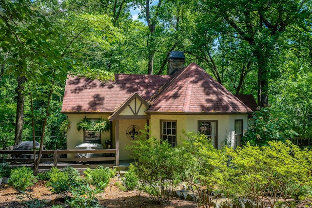 2 Mother Goose Vlg, Lookout Mountain, GA 30750 - tudor house with stucco siding, a chimney, a deck, and roof with shingles