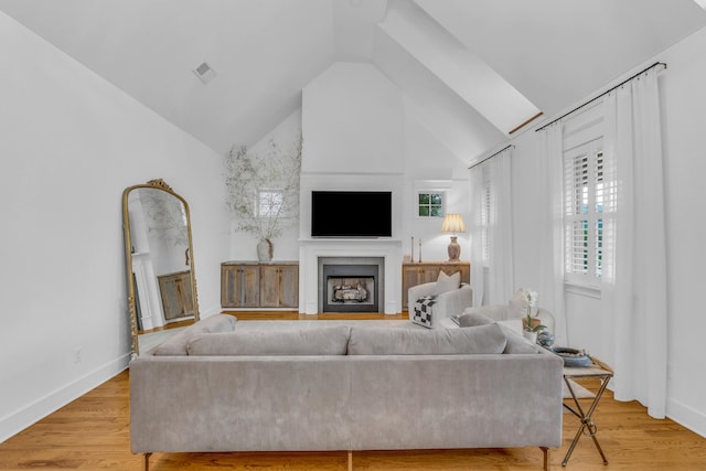 9253 Skyfall Dr, Ooltewah, TN 37363 - living room featuring a fireplace, light wood-style flooring, and high vaulted ceiling