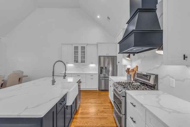 9253 Skyfall Dr, Ooltewah, TN 37363 - kitchen with stainless steel appliances, premium range hood, high vaulted ceiling, white cabinets, and glass insert cabinets
