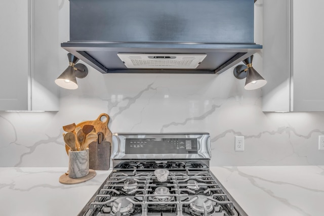 9253 Skyfall Dr, Ooltewah, TN 37363 - kitchen view of ventilation hood, gas range, backsplash, white cabinets, and light stone counters