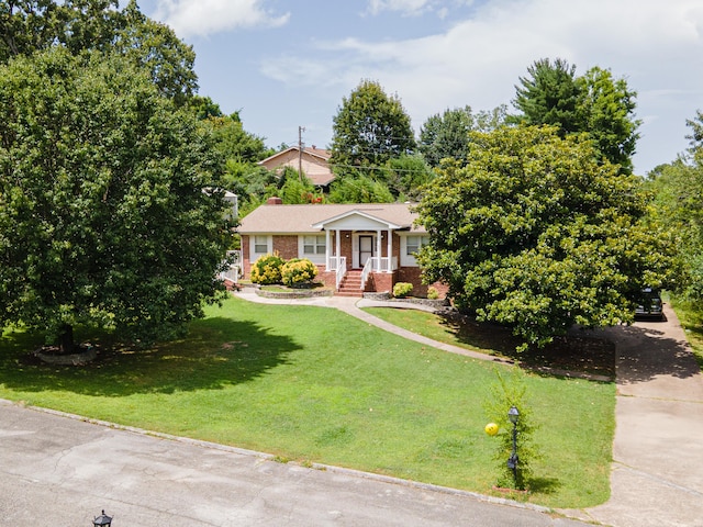 6413 Edgmon Dr, Chattanooga, TN 37421 - view of front of home with brick siding, a front yard, driveway, and a chimney