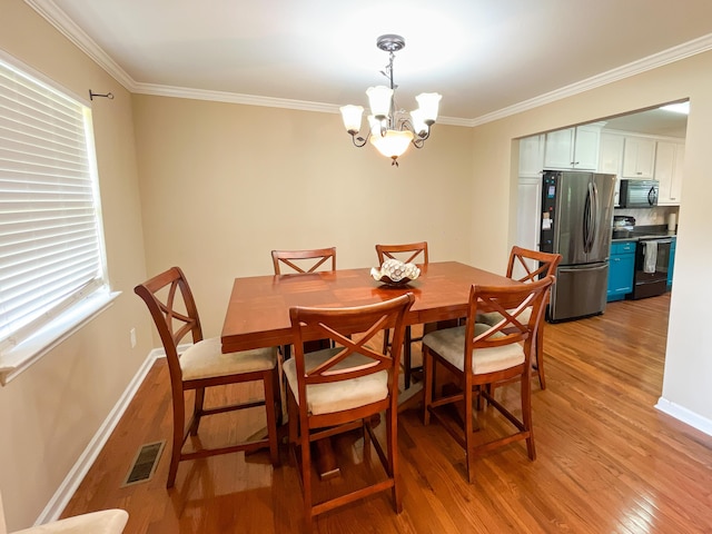 6413 Edgmon Dr, Chattanooga, TN 37421 - dining room with light wood-type flooring, a chandelier, healthy amount of natural light, and ornamental molding