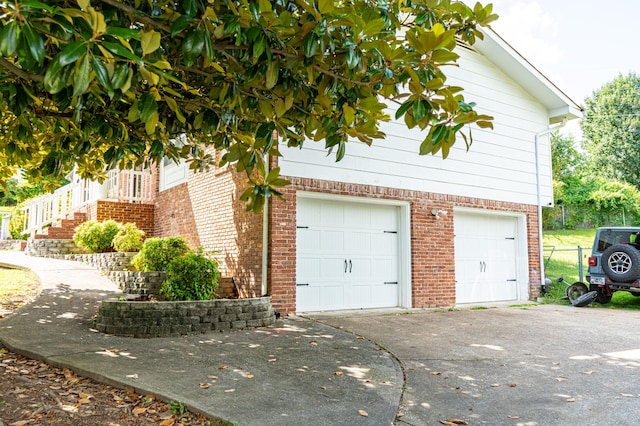 6413 Edgmon Dr, Chattanooga, TN 37421 - view of side of property featuring a garage, brick siding, and concrete driveway