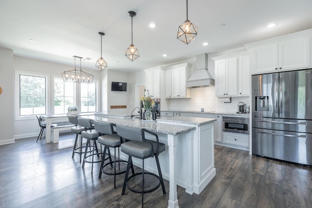 143 Walden Dr, Signal Mountain, TN 37377 - kitchen with stainless steel fridge, premium range hood, white cabinetry, a kitchen island with sink, and recessed lighting