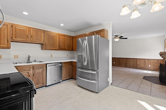 4920 Pine Cir, Ooltewah, TN 37363 - kitchen featuring stainless steel appliances, a wainscoted wall, brown cabinetry, light countertops, and a chandelier