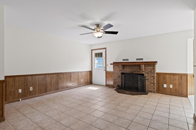 4920 Pine Cir, Ooltewah, TN 37363 - unfurnished living room featuring wainscoting, wooden walls, ceiling fan, a fireplace, and tile patterned flooring